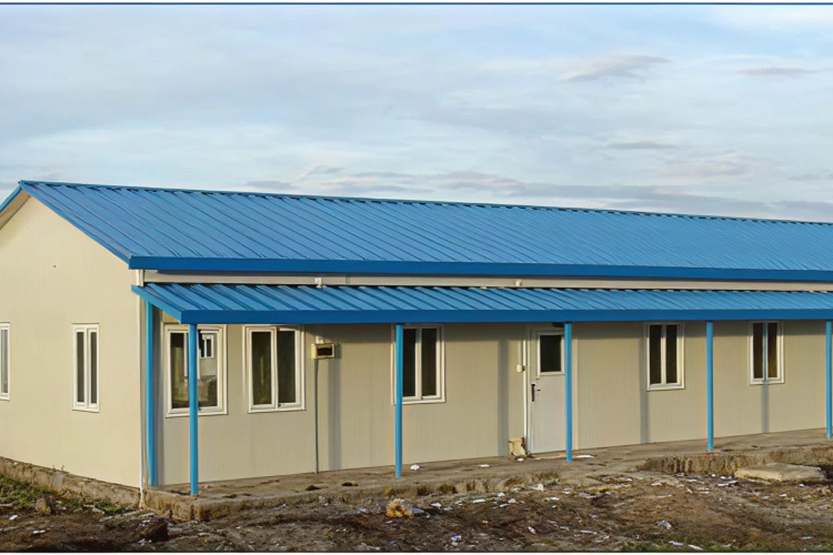 Single-story T-style prefab building with blue roof for retail use