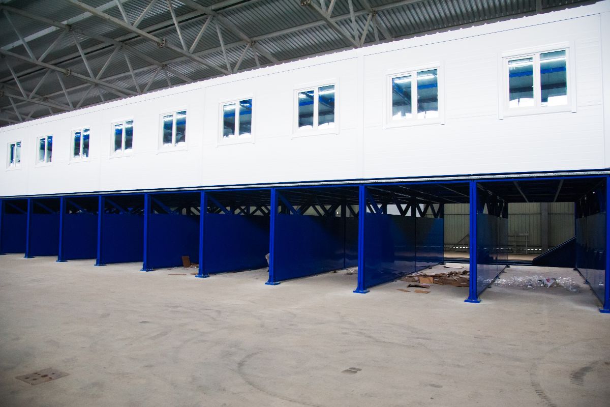 Elevated prefab container office structure inside a covered facility
