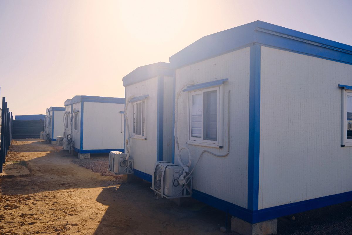 Prefab site building with exterior staircase and white modular panels for construction and industrial workspaces