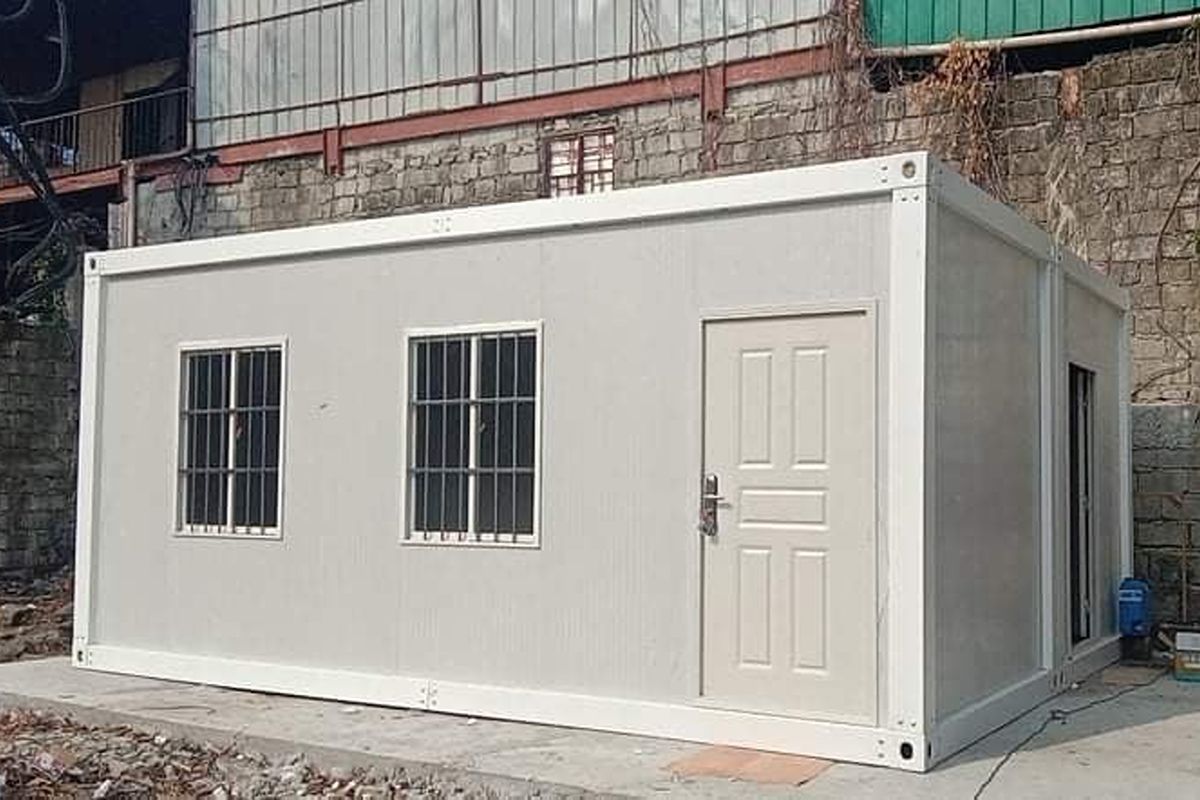 Prefab container building with windows and a door positioned at a remote worksite