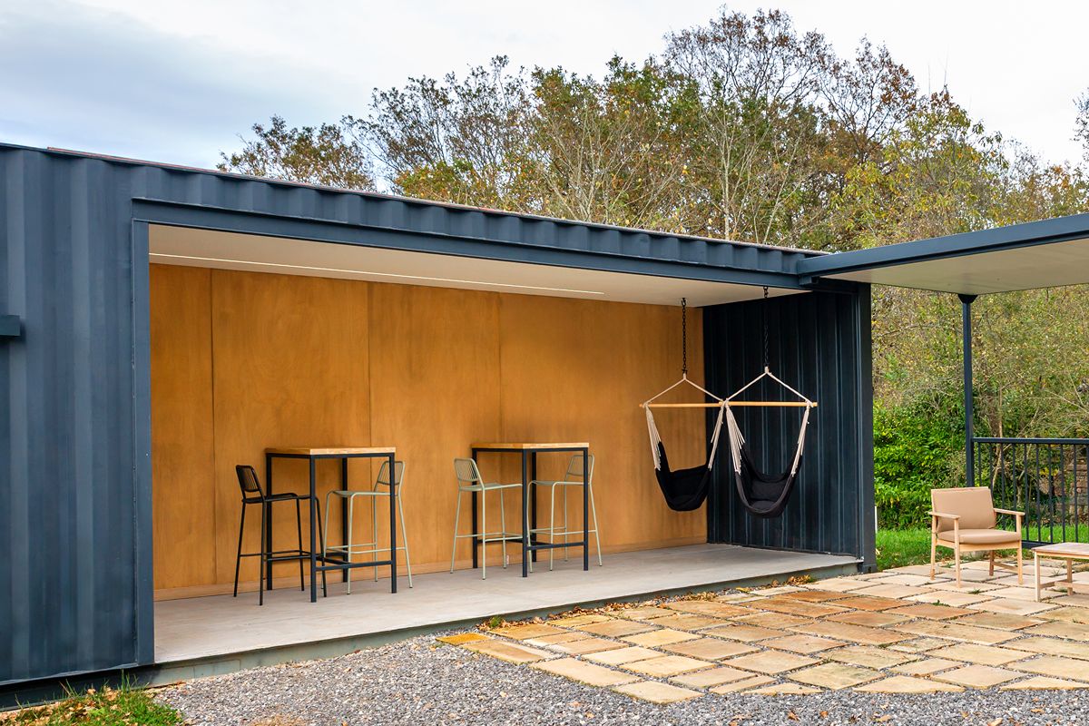 Modern modular container workspace with an open-sided layout, seating area, and outdoor patio