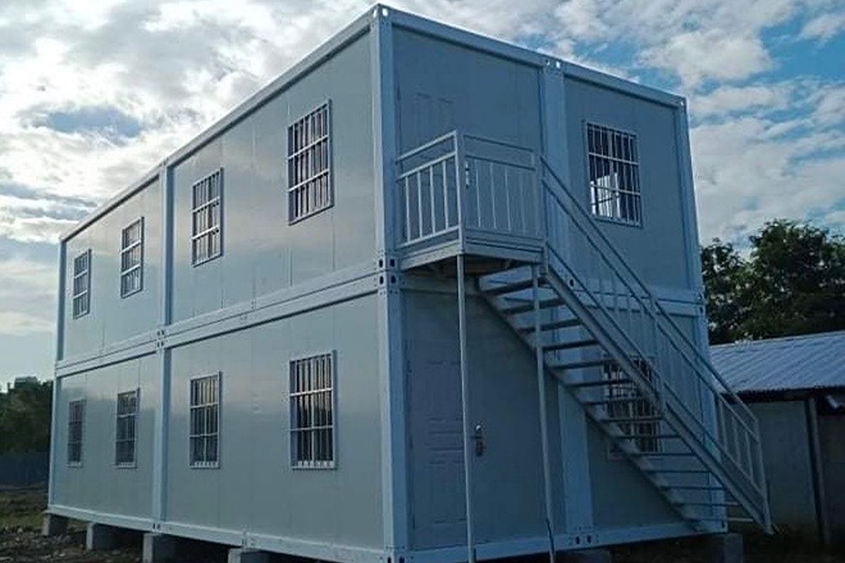 Two-story prefab container facility with multiple windows and an exterior staircase for classrooms or training spaces