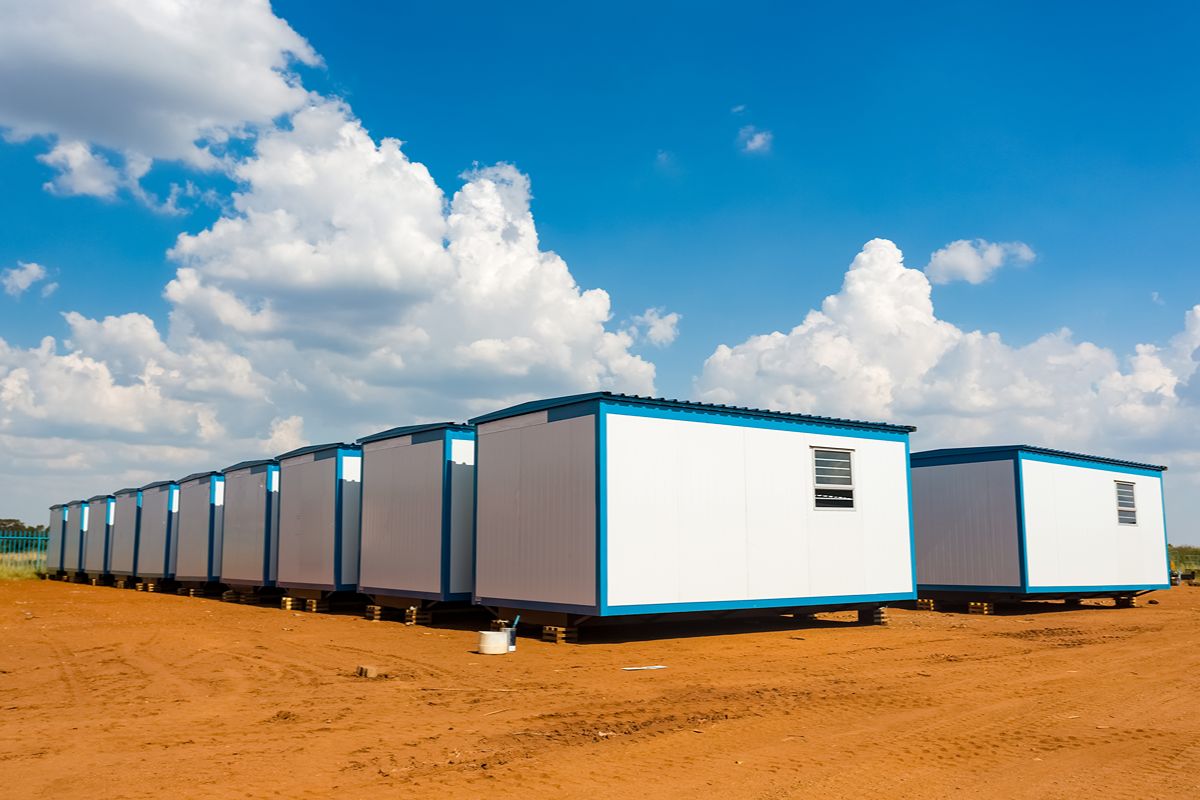 Row of modular prefab office units installed on an open industrial site