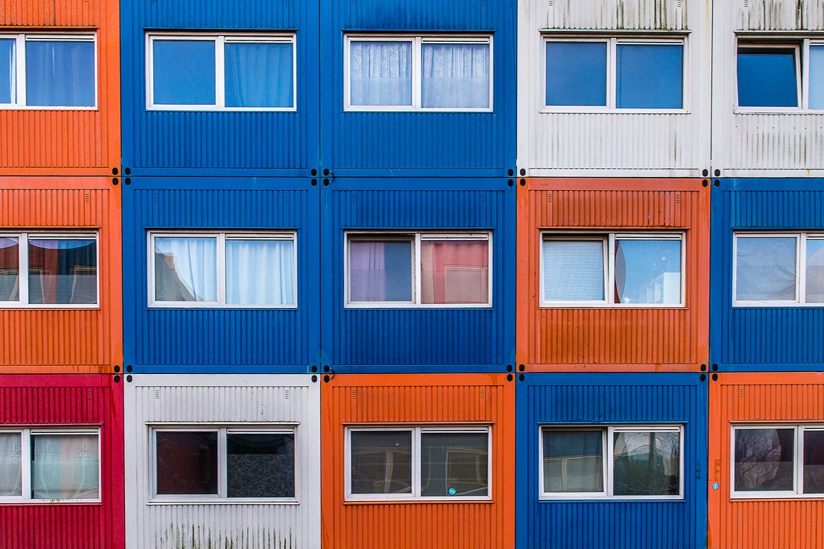 Multi-level modular container offices with colorful exterior panels and multiple windows