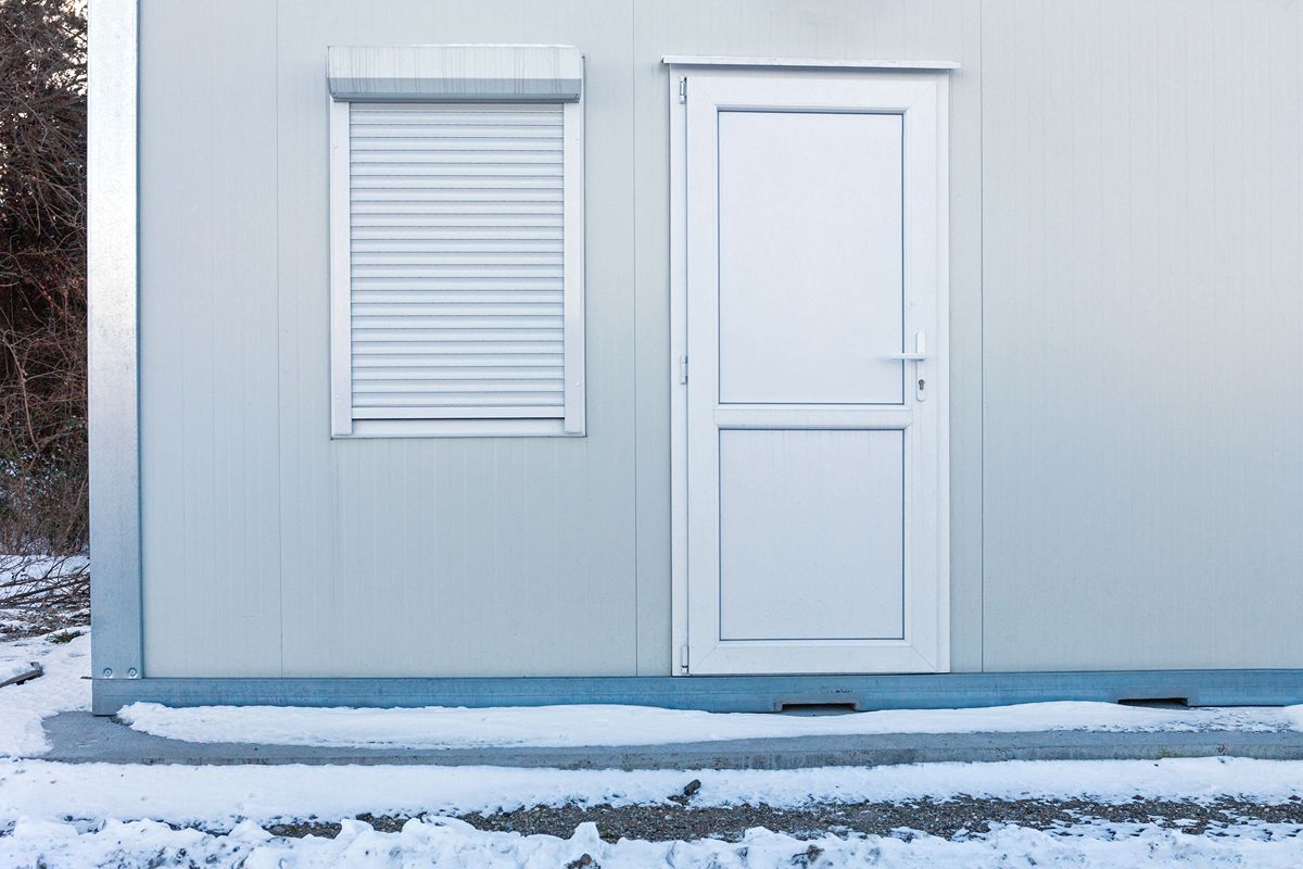 Compact prefab container office with a door and shuttered window for flexible factory use