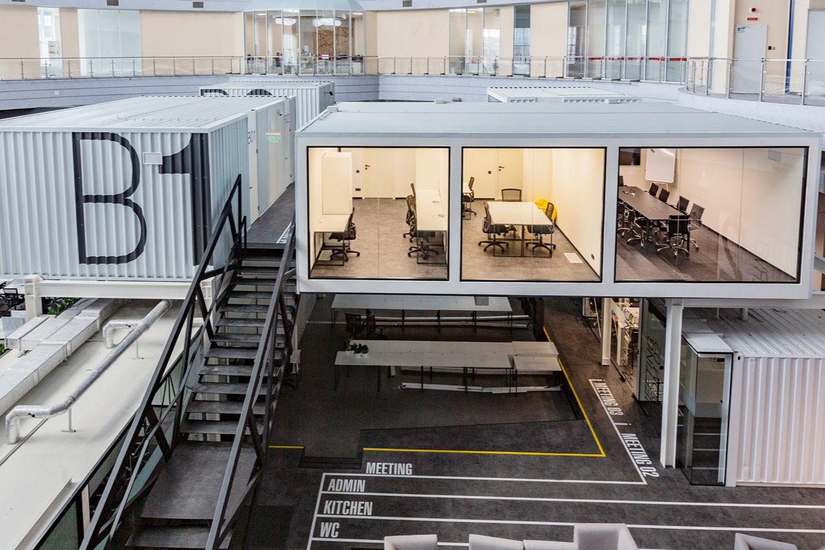 Elevated modular office with large glass windows installed inside an industrial facility